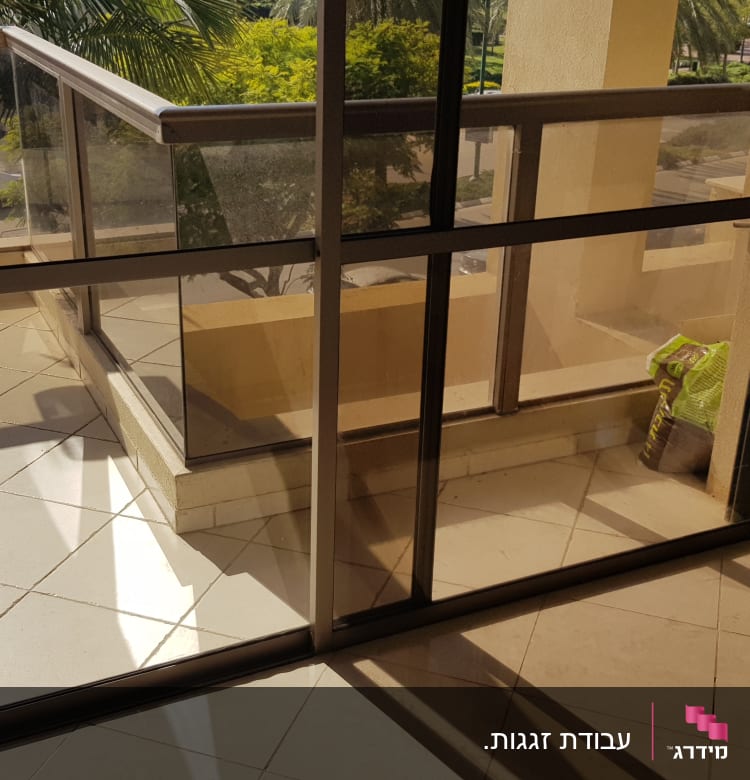 מעקה זכוכית במרפסת עם צל על הרצפה